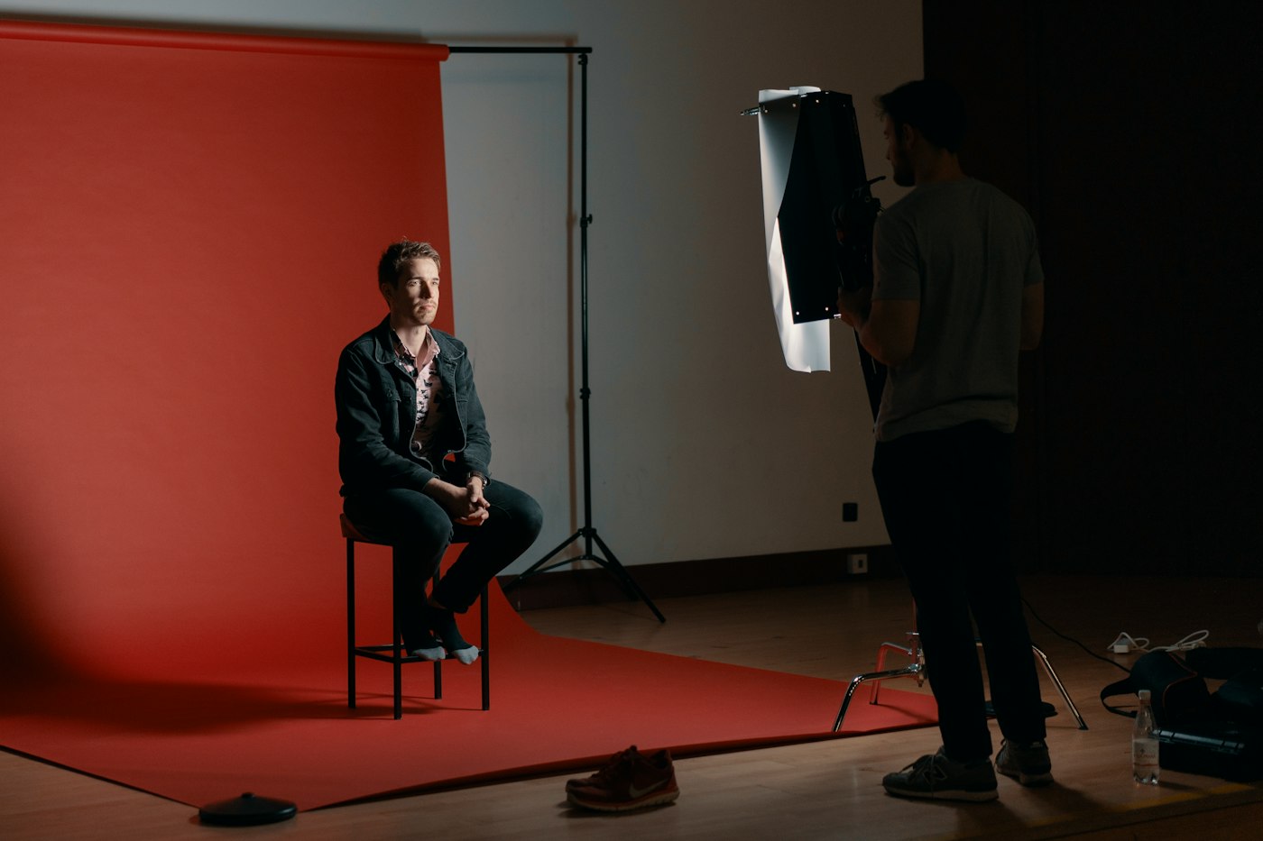 Behind the scenes of a studio portrait on a red backdrop