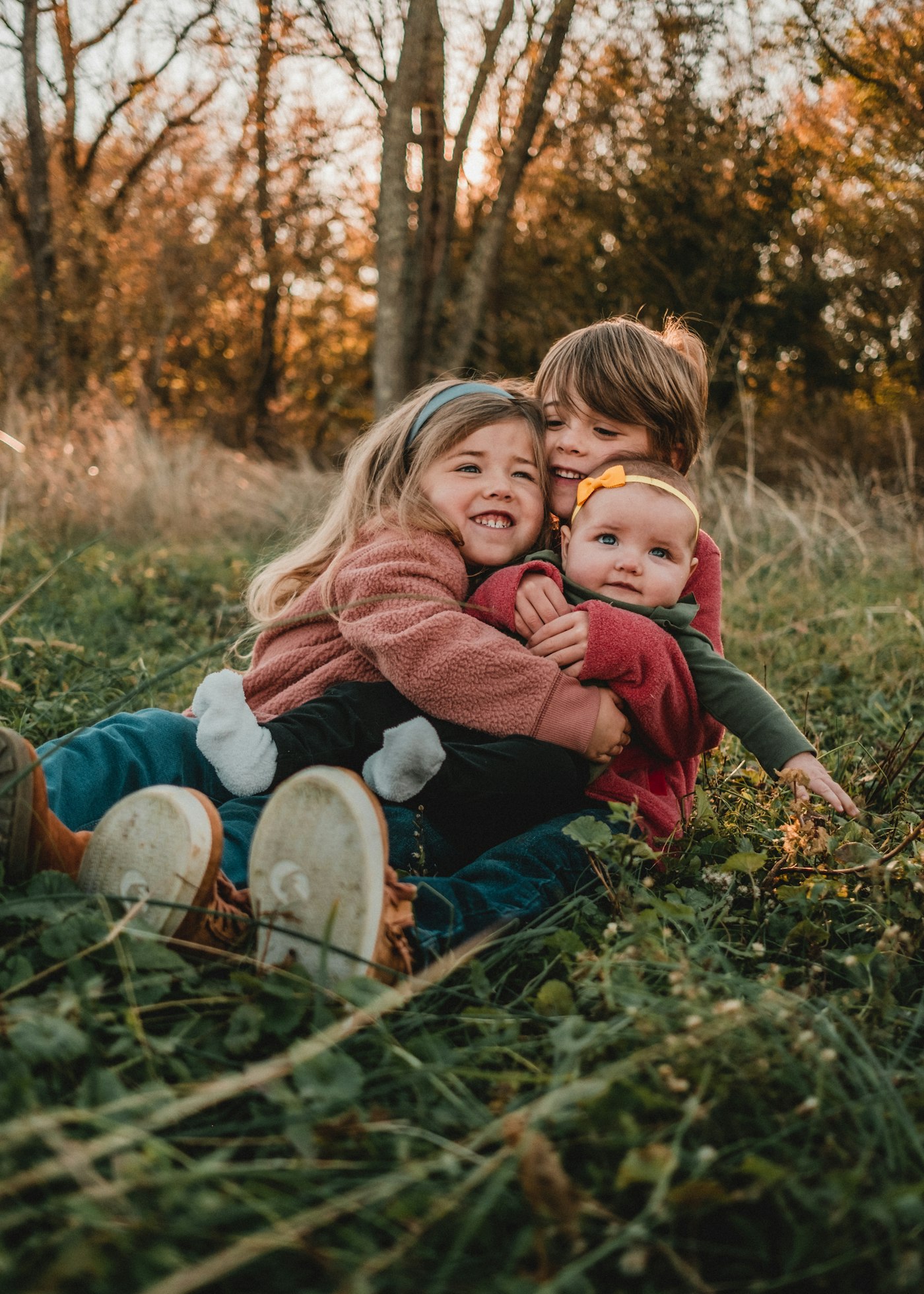 Two young siblings hugging in the grass